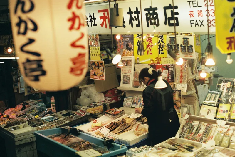 A woman working at a seafood stall in a Hokkaido fish market, Japan